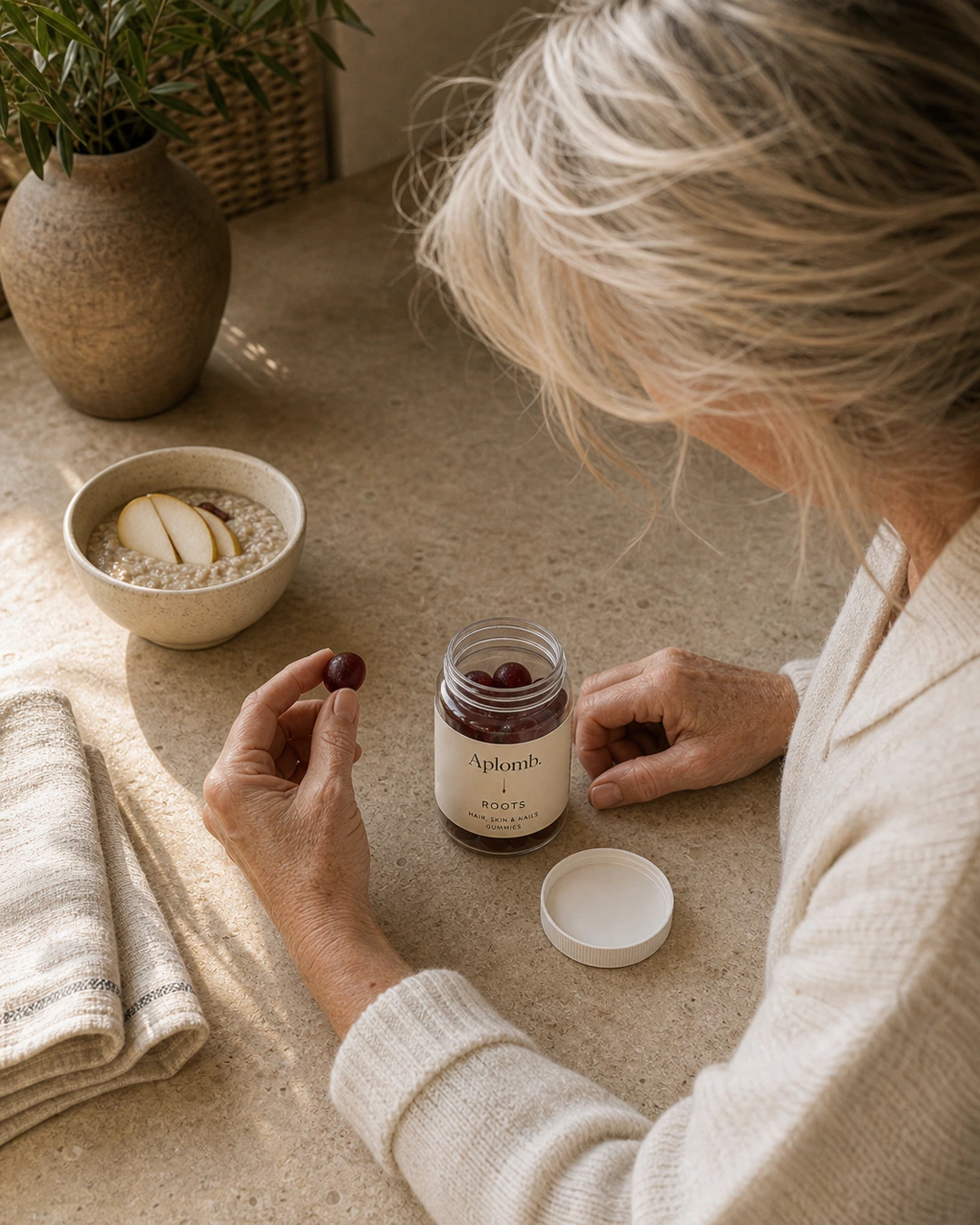 Woman taking an APLOMB Roots gummy at the breakfast table