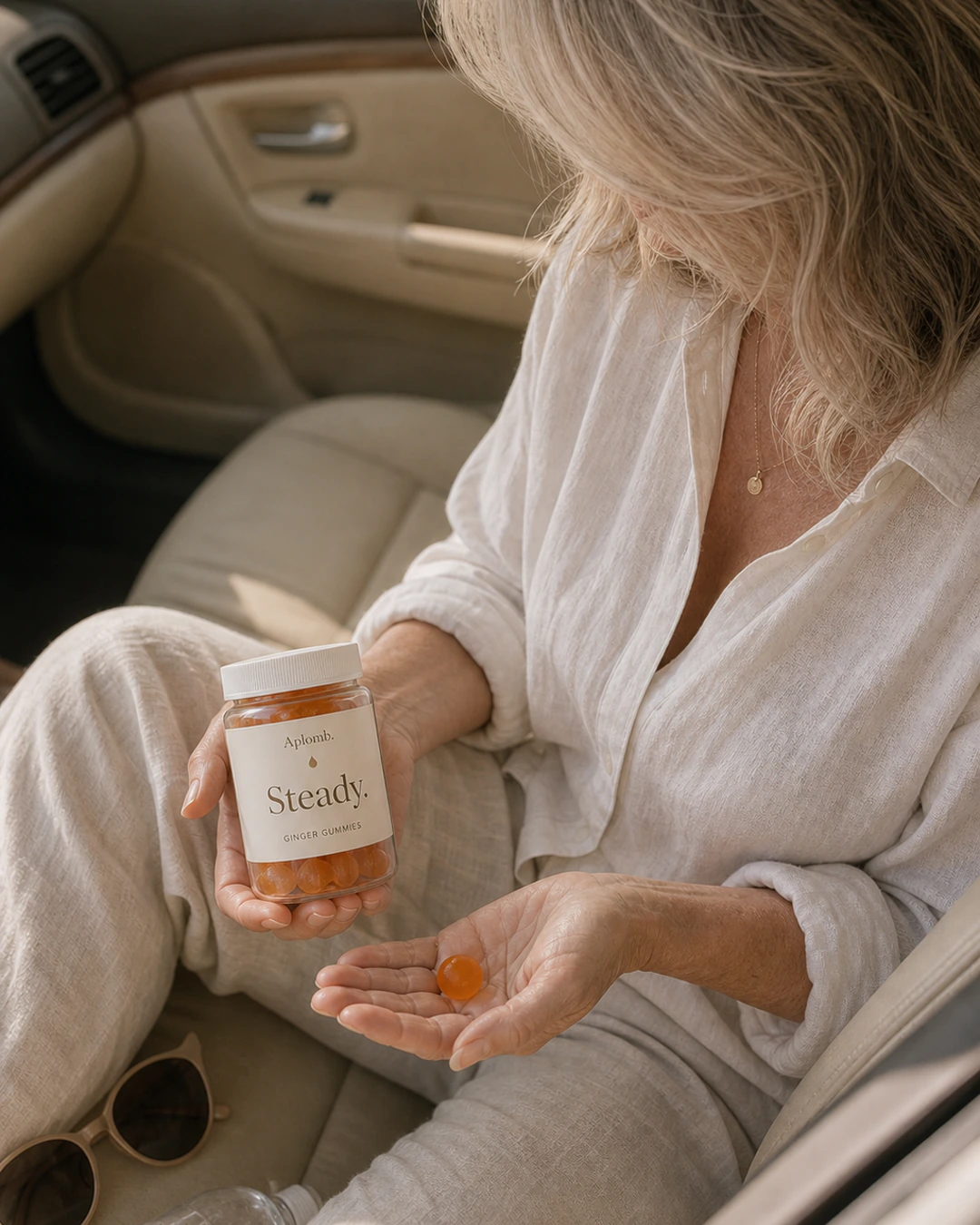 Woman holding APLOMB Steady gummies during a pause in her parked car