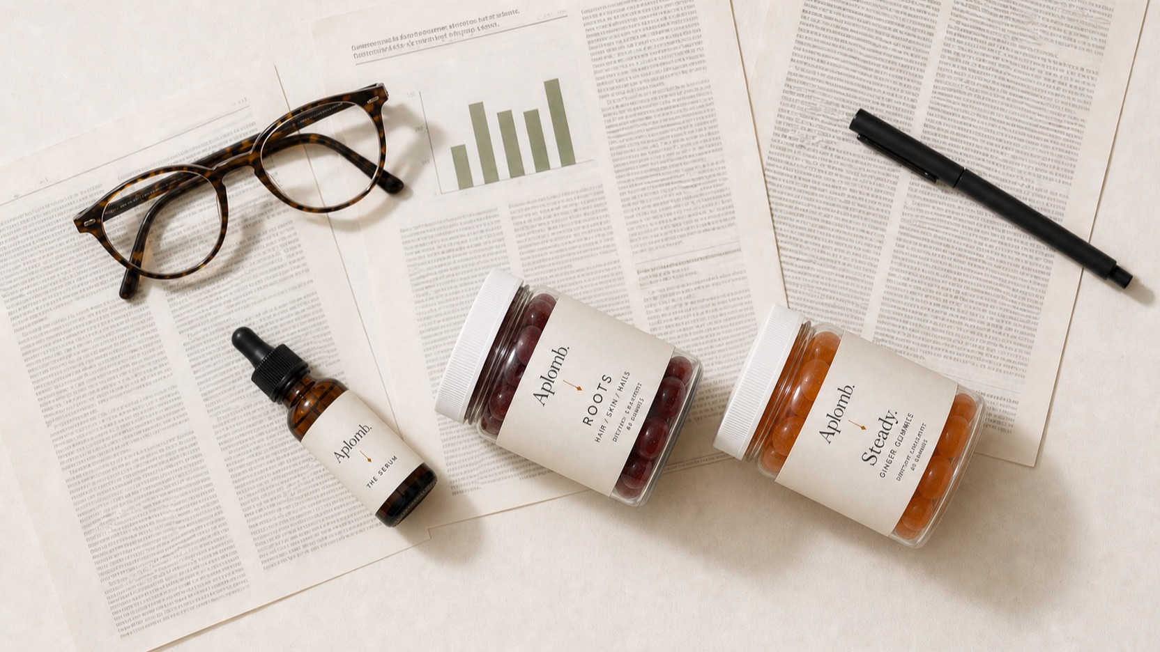 Printed clinical studies, reading glasses, and APLOMB products laid out on a desk